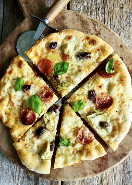 Hvit pizza med spekepølse, artisjokker og oliven