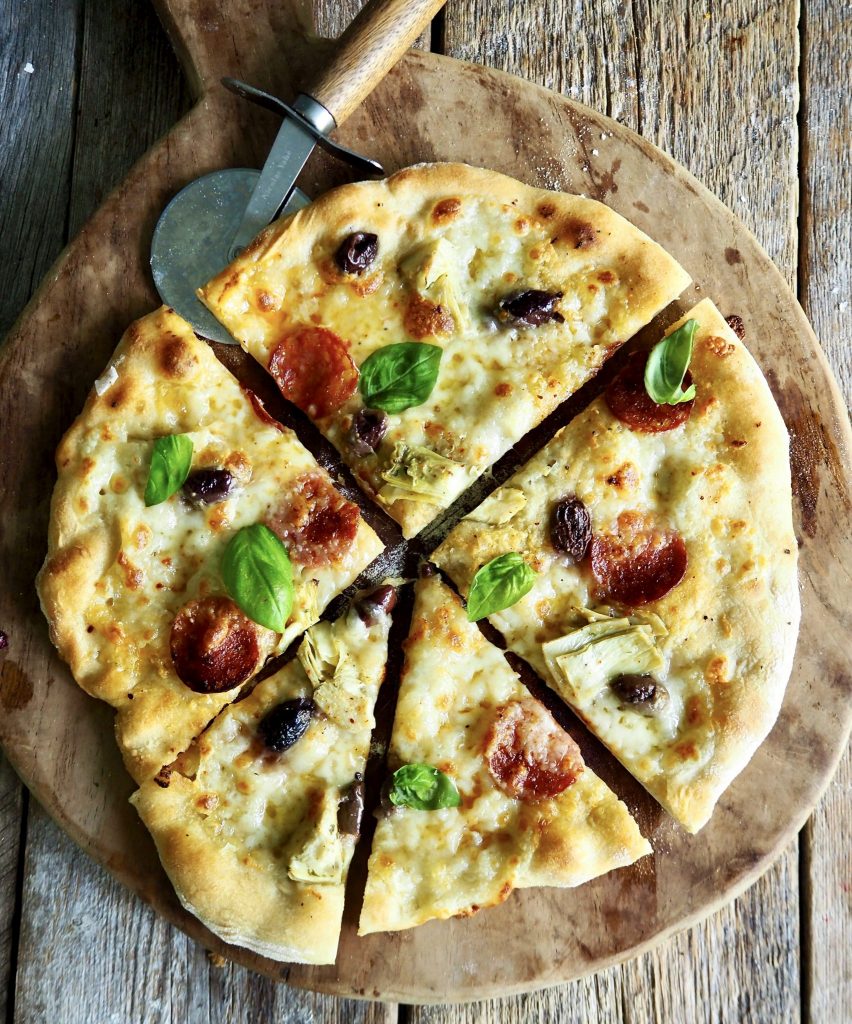 Hvit pizza med spekepølse, artisjokker og oliven